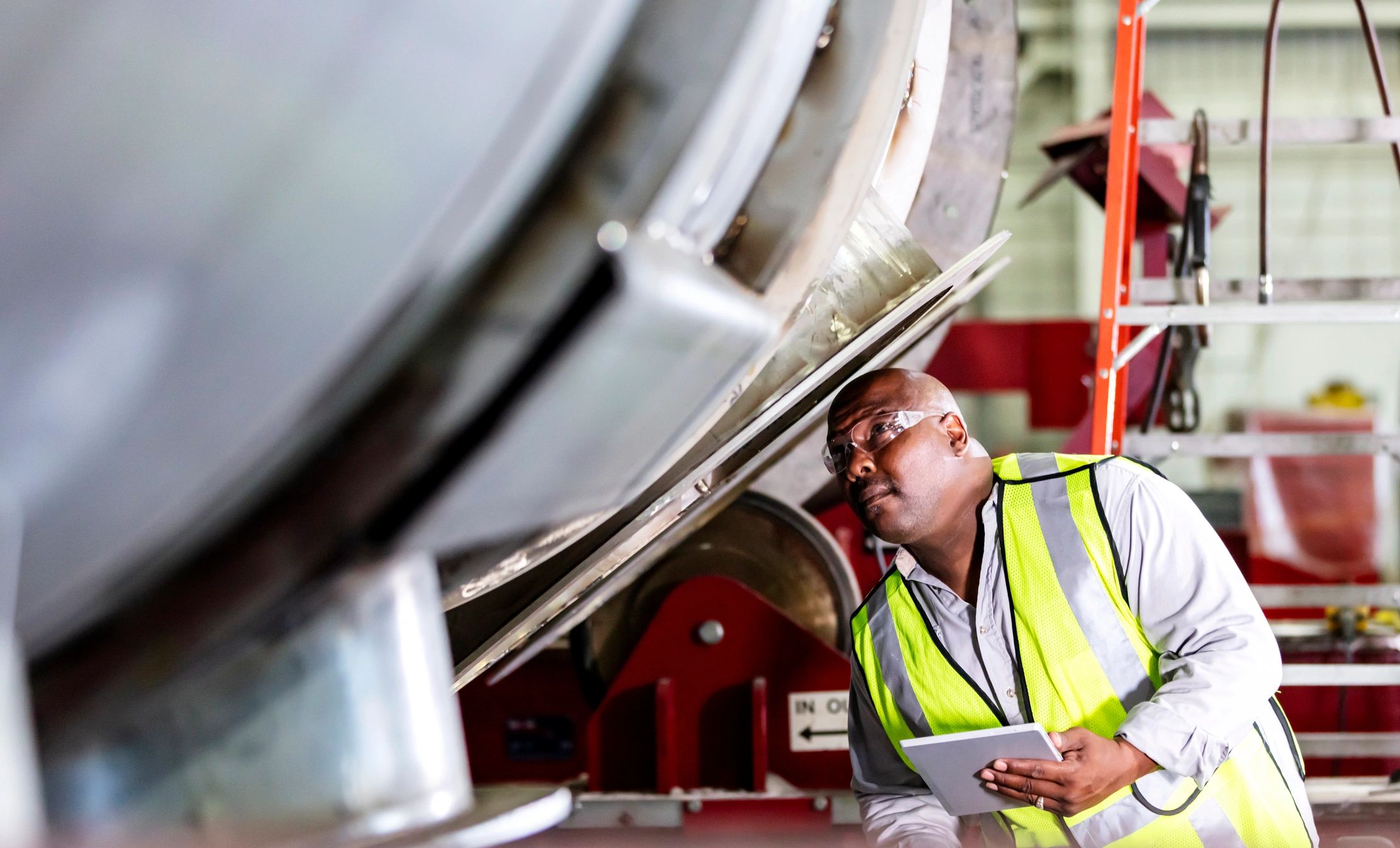 Worker using a tablet to inspect industrial equipment