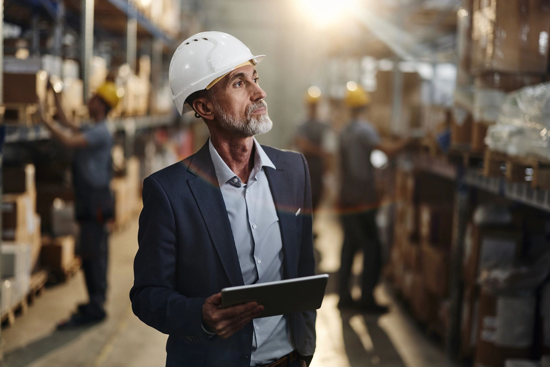 Facilities manager using a tablet in a warehouse environment.