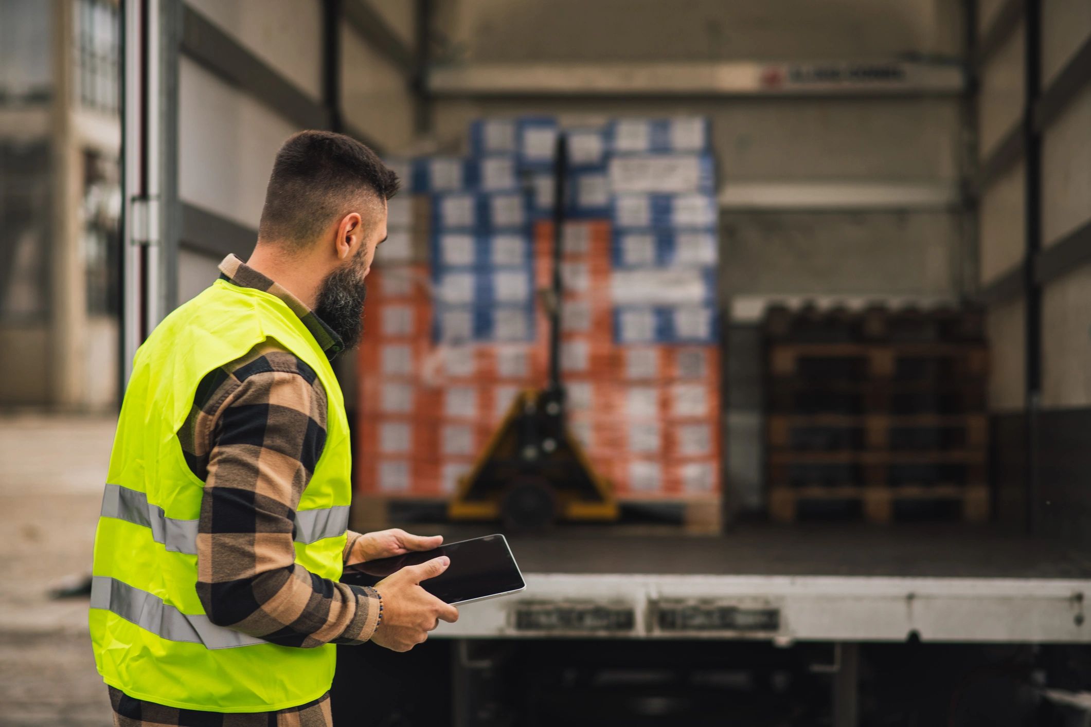Technician reviewing inventory information on a tablet near a truck